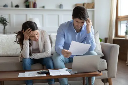 148137492-ansiosa-pareja-joven-caucásica-se-siente-estresada-manejando-las-finanzas-del-hogar-documentos